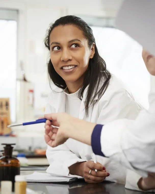 A female scientist smiles at a colleague