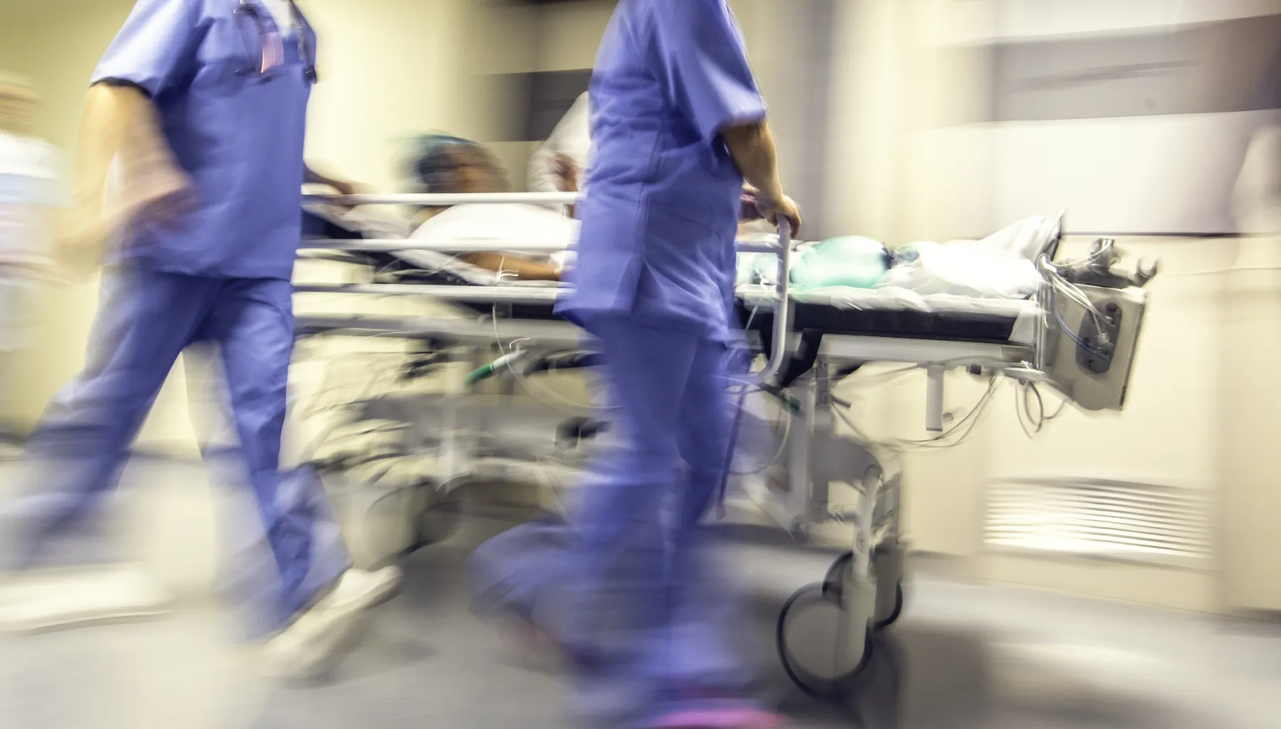 Doctors and nurses pulling hospital trolley